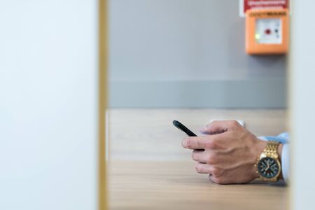 Businessman holding mobile phone in his hand trying to type a message.の写真素材