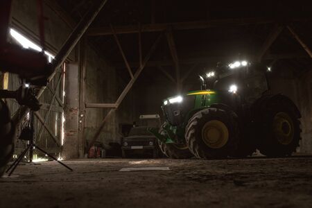John Deere modern tractor parked in barn ready to drive outside for the field. April 6 2017 Wroclaw, Poland.のeditorial素材