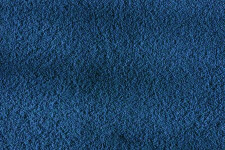 Distressed overlay texture of cracked concrete, stone or asphalt. Grunge blue background. Small grains of sand as a wallpaperの写真素材