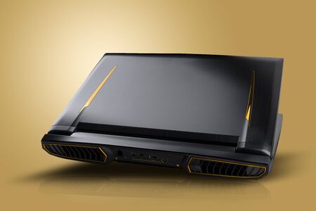 Gaming laptop on golden yellow background. Laptop designed for gamers or professional players or 3d renderingの写真素材