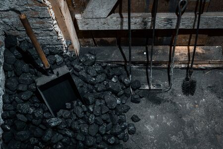 A coal shovel stuck in a pile of coalat the basement prepared for heating the house with.の写真素材