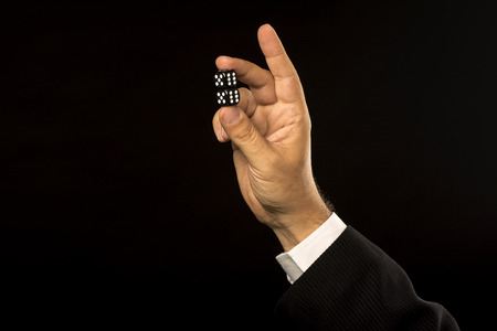 Hand with dices on black backgroundの写真素材