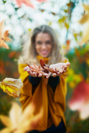 Woman with leaves on hands, autumn