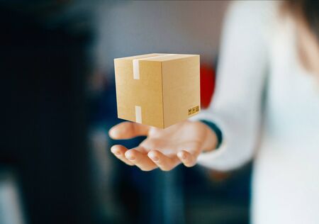 Hand with cartboard box, shipping conceptの写真素材