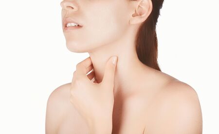 Beautiful casual woman is having sore throat. Isolated on white