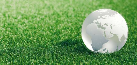 Glass globe or earth in green grass showing eco concept with copyspace, 3d renderingの写真素材