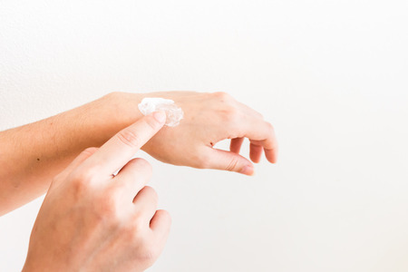 apply medicine to left wrist due to sprainの写真素材