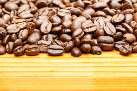 Close up of coffee beans on upper side and blank area at lower side on wooden tableの写真素材