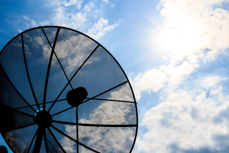 satellite dish and cloudy sky with sunbeam in afternoon (Silhouette style)の写真素材