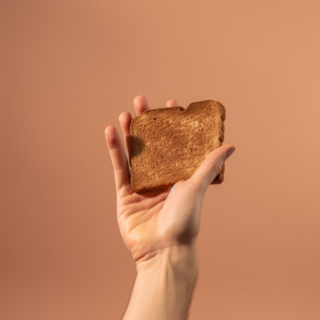 person holding toasted bread against an orange background in a minimalist surrealism style. the unpolished authenticity of the image is reminiscent of artists such as daan roosegaarde and rachel whiteread. the photo features a photo-realistic composition that is characteristic of the bloomcore aesthetic. ai generatedの素材