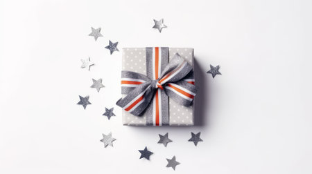 a striped present bow with a star on a white background is captured in this tabletop photography. the dark silver and orange color combination is enhanced by confetti-like dots. the high-key lighting and bold color palate of light gray and gray create an orderly arrangement. ai generatedの素材