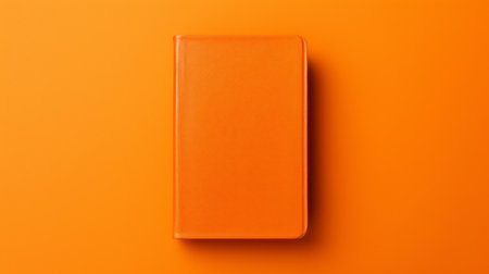 an orange book, set against a background of vibrant orange, showcases the essence of color field minimalism. this high-detailed photograph, captured with back button focus, is perfect for studyblr enthusiasts. the realistic and detailed rendering of the book is packed with hidden details, making it a visually captivating matte photo. ai generatedの素材