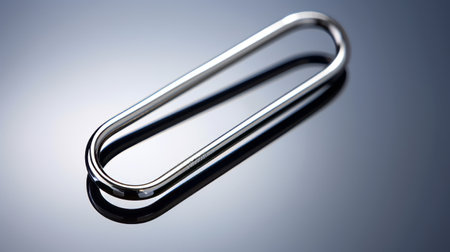 blue background with a small silver wire resembling paperclips, inspired by the industrial and product design of georg jensen. captured using the tokina opera 50mm f/1.4 ff lens, the image showcases an elongated and dramatic composition. influenced by the artistic style of jean-joseph benjamin-constant. ai generatedの素材