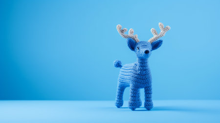 blue knitted reindeer with red eyes on a monochromatic depth blue background. this unique piece, crafted with organic materials, showcases a multi-coloured minimalistic design. captured with a konica big mini camera, the delicate knitted and crocheted details are beautifully highlighted. shot at iso 200, this photo exudes a sense of charm and artistry. ai generatedの素材
