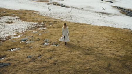 a woman gracefully walks on a flowery mountain, surrounded by snow and seagulls. the aerial view captures the beauty of the beige and amber landscape. these atmospheric portraits, inspired by ragnar kjartansson, showcase a simple and elegant style. candid moments are captured, creating a joyful celebration of nature. ai generatedの素材