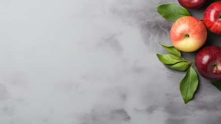 a bunch of fresh red and green apples is beautifully arranged on a grey background. the photo features delicate flowers, abstract minimalist forms, and elements of marble, silver, and pink. with copy space and copy text, it captures the essence of industrial and product design. the ethereal foliage adds a touch of enchantment. iso 200 ensures a high-quality image. ai generatedの素材