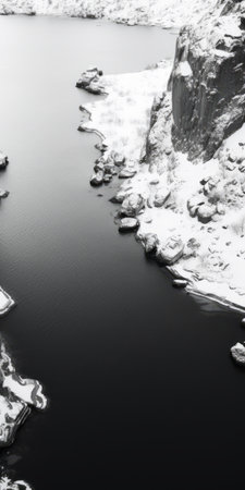 aerial view of a winter river captures the monochromatic contemplation in the style of nicolas delort. the photorealistic detail highlights the organic stone carvings along the riverbanks, while the black and white contrast adds depth to the scene. valentin serov's influence is felt through the meditative color contrasts, creating a mesmerizing composition. ai generatedの素材