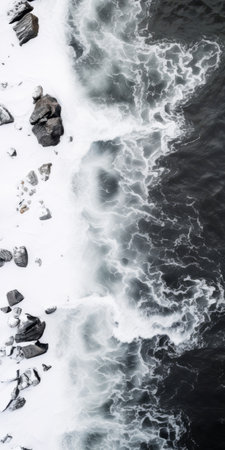 snow-smashed rocks line the shore of an iceberg, creating a captivating aerial abstraction. the contrasting shades of dark white and dark gray form a mesmerizing birds-eye-view. this contemplative minimalist scene showcases the beauty of nature, with reefwave patterns and naturalistic ocean waves adding to the allure of this norwegian landscape. ai generatedの素材