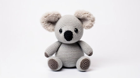 the adorable knitted koala toy sits serenely against a pristine white background, showcasing its intricately stitched features and soft, cuddly texture, perfect for snuggling and playtime, making it an ideal gift for kids and koala enthusiasts alike, evoking feelings of warmth and comfort. ai generatedの素材