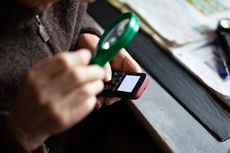 Old man uses mobile phone closeupの写真素材