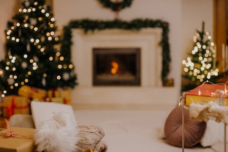 Cozy living room, lights decorated ready to celebrate Christmas. Christmas room interior, Christmas tree decorated with lights, candles and lighting garlands indoors fireplace.の写真素材
