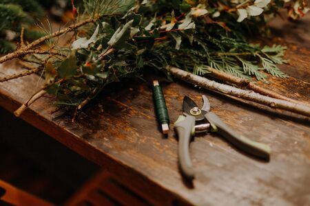 Top down view of florist's worktable. Handmade xmas decorations. Making rustic christmas wreath. Authentic rural wreathの写真素材