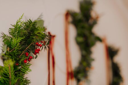 modern Christmas wreath. stylish rustic christmas wreath with pine cones,fir branches,snow, hanging on white wall. handmade decor for winter holidaysの写真素材