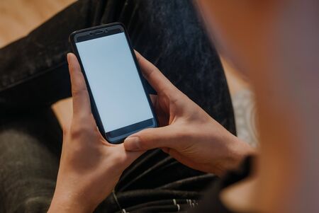Man holding smart phone with blurred background. For Graphic display montage.の写真素材