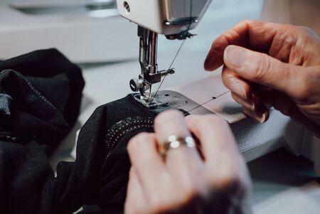 Close up of womans hands sewing on the sewing machine