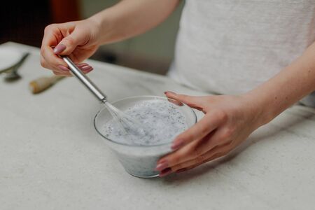 Close Up Woman Hands Mixing of Chia Pudding in Glass Bowl in Kitchenの写真素材