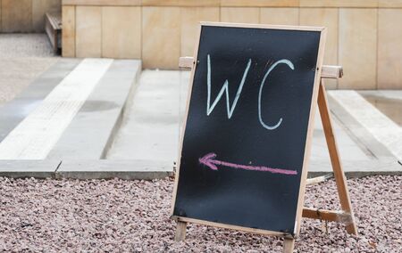 toilet sign on board in front of the entranceの写真素材