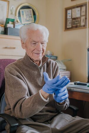 Old man wearing Protective Gloves against Covid-19の写真素材
