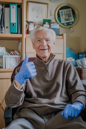Old man wearing Protective Gloves against Covid-19の写真素材