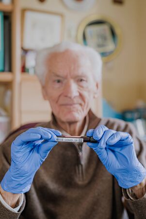 Old man holding Covid-19 sampleの写真素材