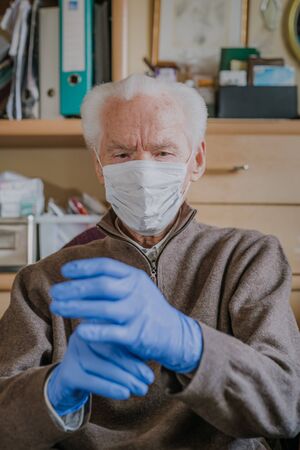 Old man wearing protective mask and glovesの写真素材