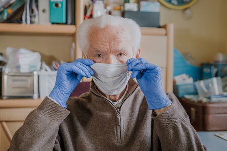 Old man wearing protective mask and glovesの写真素材