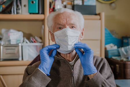 Old man wearing protective mask and glovesの写真素材