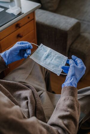 Senior holding protective mask in his handsの写真素材