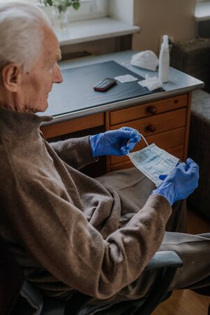 Senior holding protective mask in his handsの写真素材