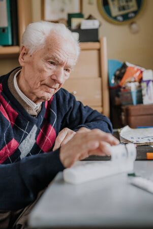 Senior arranges medicines for each day of weekの写真素材