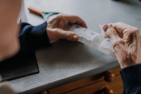 Senior arranges medicines for each day of weekの写真素材