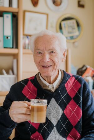 Old man drinking coffee at homeの写真素材