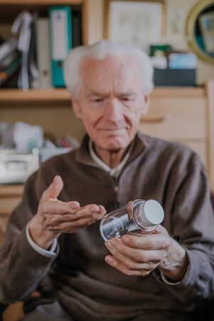 Senior holding an empty medicine bottle