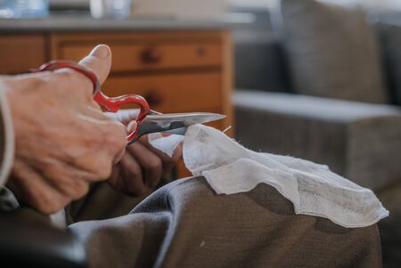 Senior preparing dressing, cuts gauze closupの写真素材