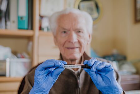 Old man holding Covid-19 sampleの写真素材