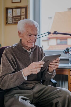 Positive Senior using Digital Tabletの写真素材