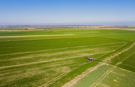 Farmer Working in Field - Agriculture Tractor Spraying Chemicals on field. GMO food Production.の写真素材