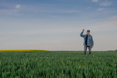 Portrait of Successful Farmer Examining Crops at Agriculture Field. Farmer Looking at Crops Wheat Fieldの写真素材