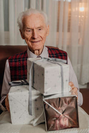Senior Man Holding Christmas Gift in Hands on Christmas
