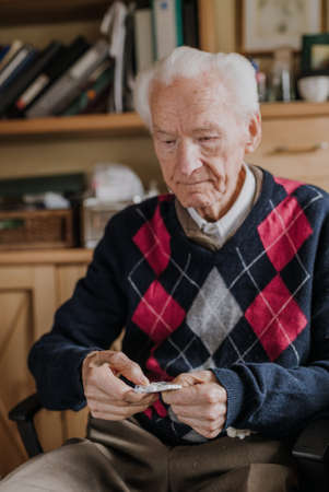 Old man holding medicine blister in handsの写真素材